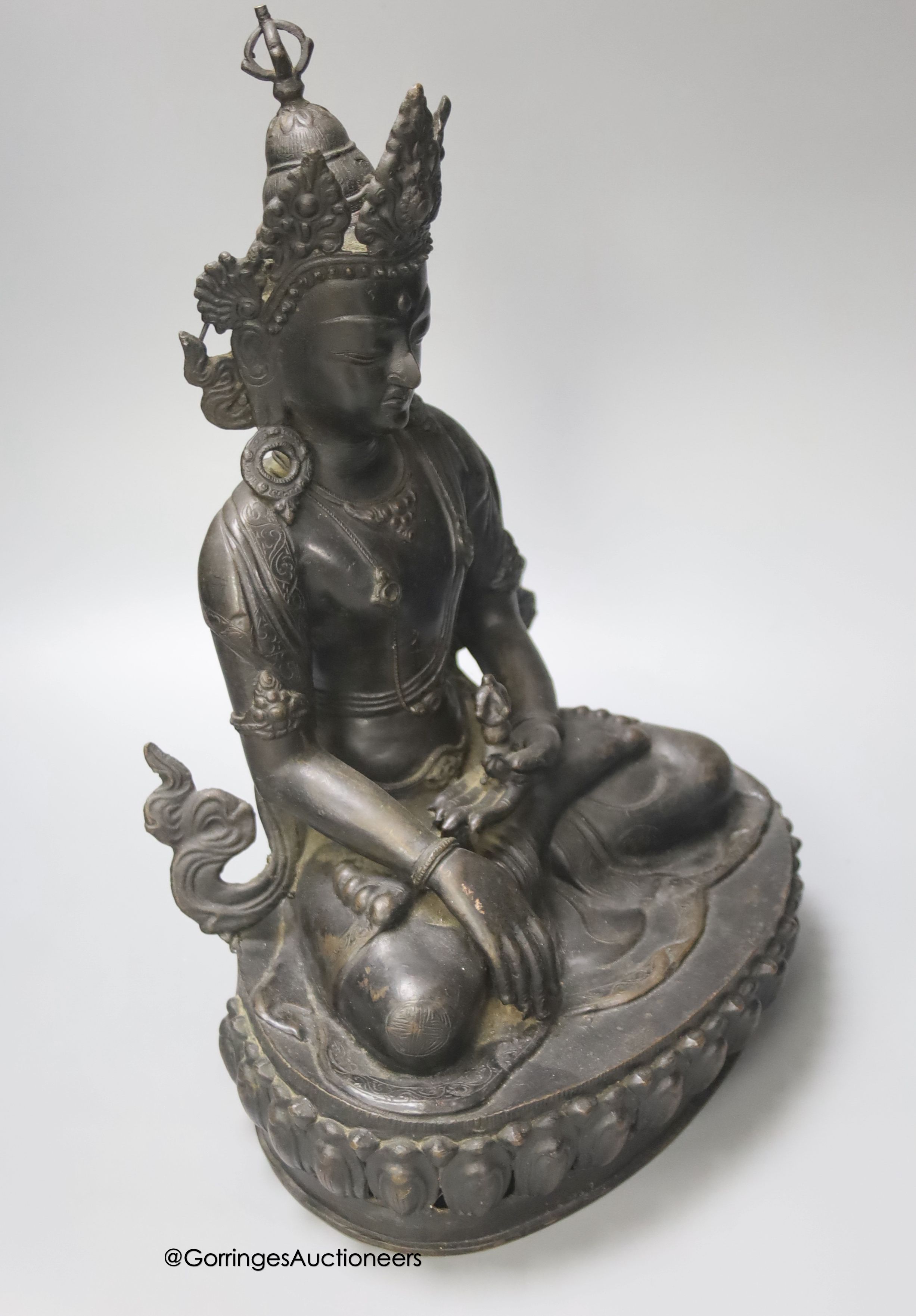 A bronze figure of a Bodhisattva, seated on an oval lotus base, 36cm